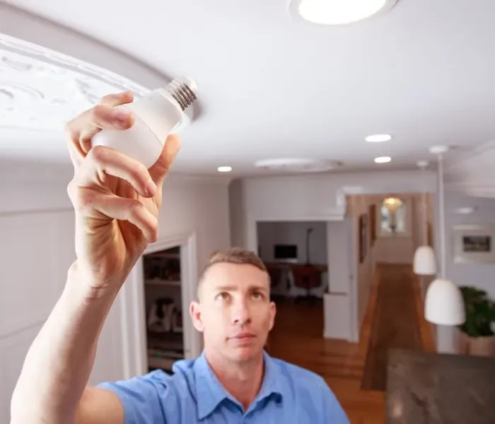 Electrician replacing a light bulb