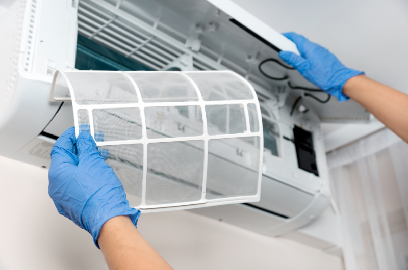 professional air conditioning technician cleaning split system air conditioner filters. clean filters can save you money and extend the lifespan of your air con system