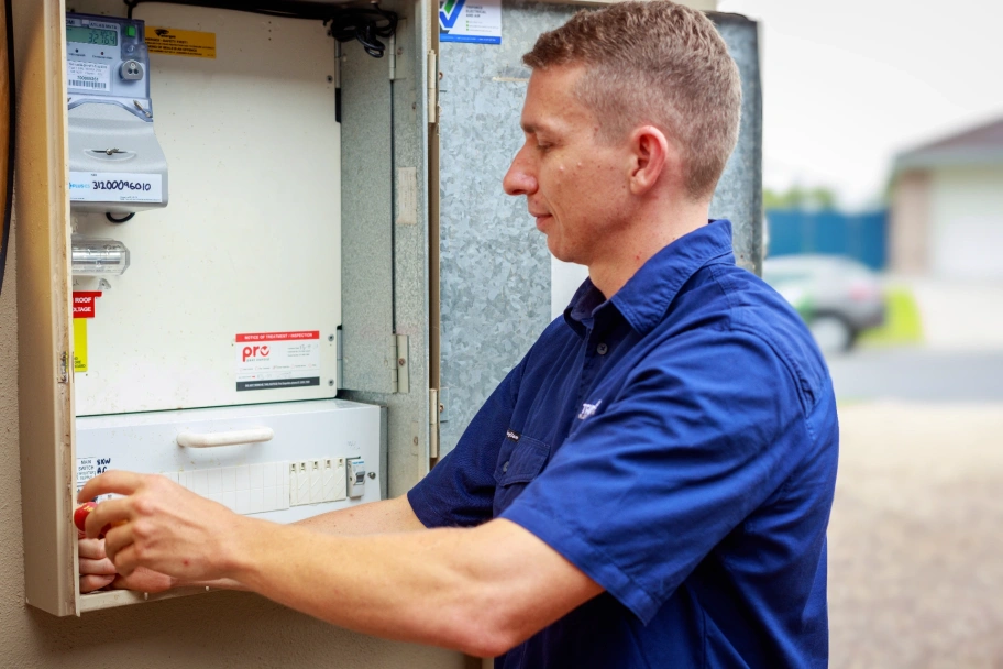 Electrician inspecting & testing a switchboard to assess whether an upgrade is required