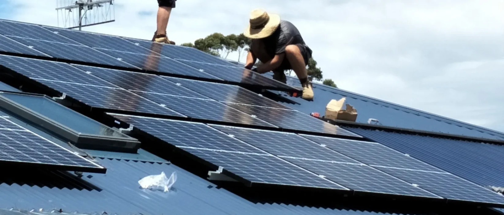 technician on roof working on solar panels