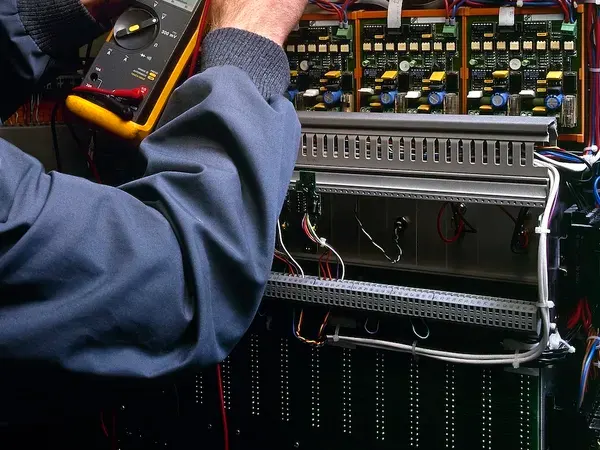 technician doing an electrical test on an electrical power board