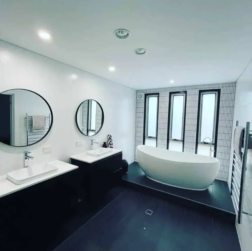 modern bathroom with tub and dual sinks