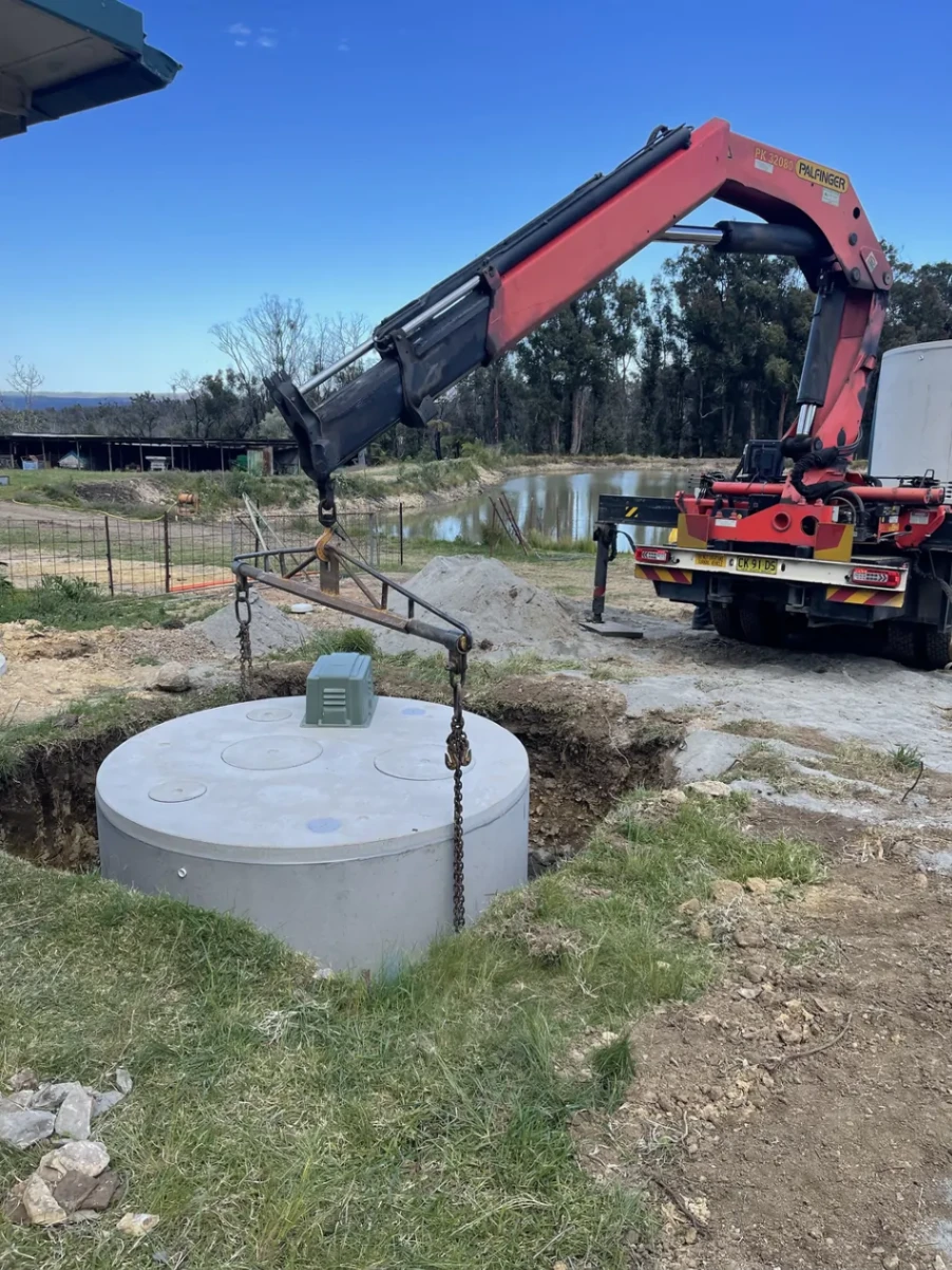 septic tank being lowered into the ground