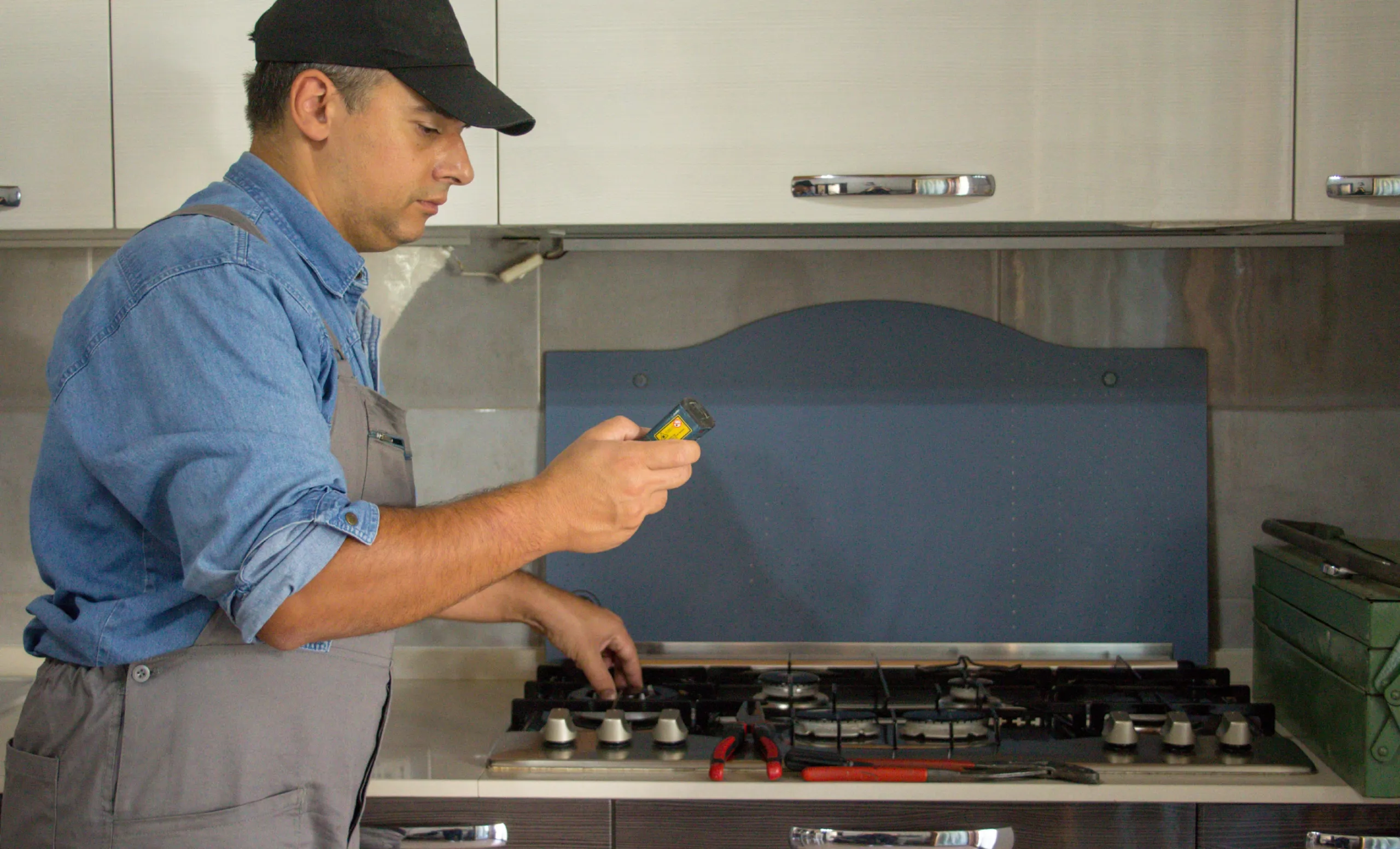 Technician checking component on a gas stove top