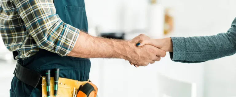 Plumber shaking clients hand