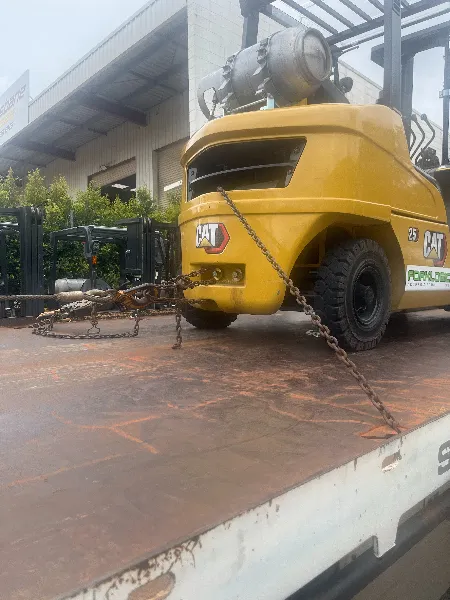 Forklift with chain restraints on truck