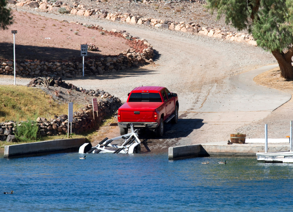 Concrete boat ramp has been built to the end of the road at perfect slope for a car to be pulling an empty boat trailer from the water easily.