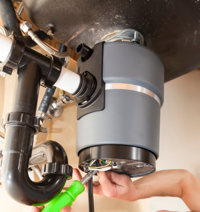 Plumber installing a new insinkerator sink garbage disposal unit under a sink