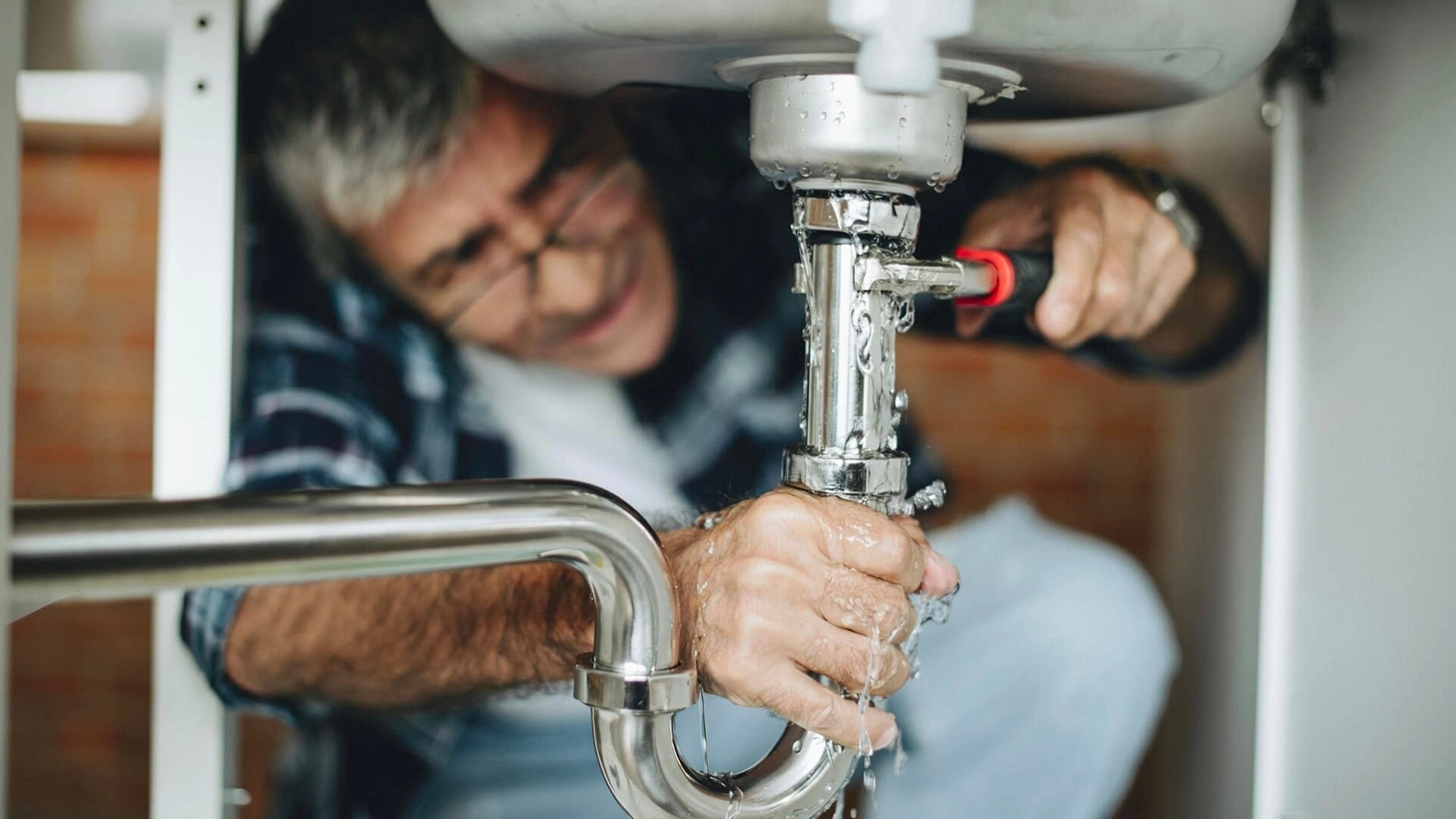 Man Fixing Leaking Pipe