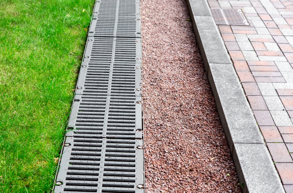 Channel drain professionally installed in a backyard to divert rain runoff away from the property and foundations. no surface water flooding anymore with a channel, trench or french drain