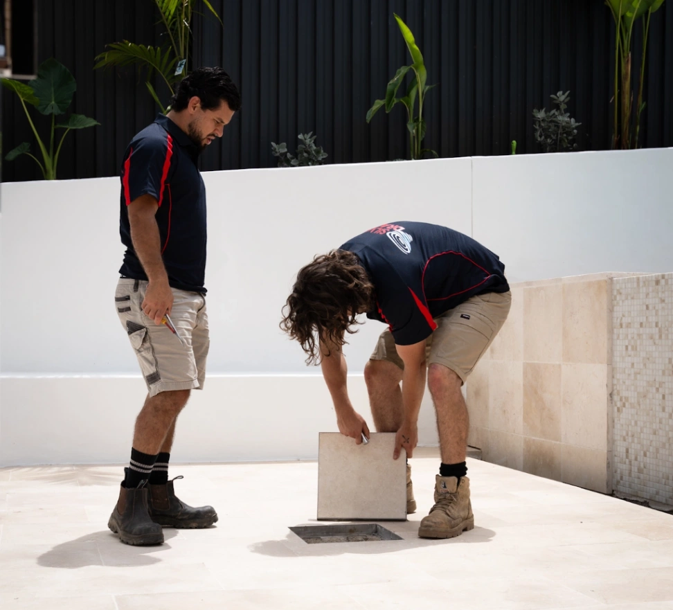 plumbers checking drain in pool area