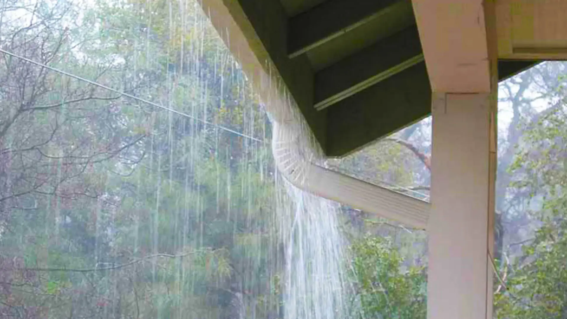 Heavy rainfall coming out the sides of the gutters