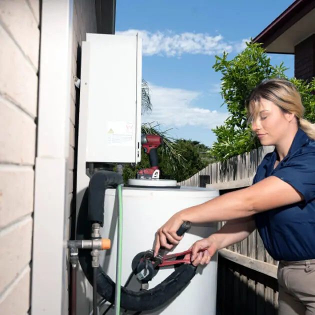 plumber fixing hot water system