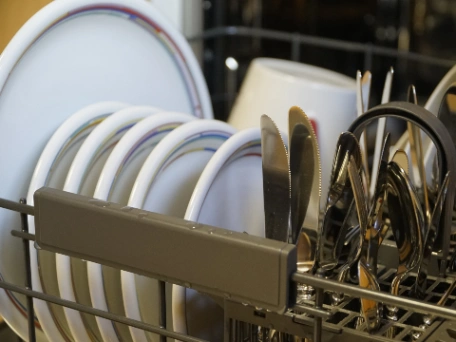 A dishwasher full of clean plates and cutlery
