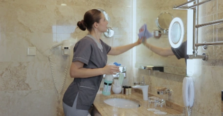 Cleaning bathroom tiles and grout with a cloth and cleaning products