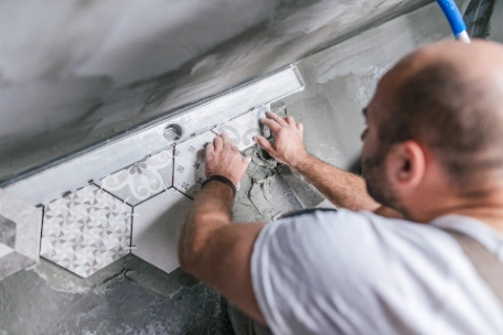 Hexagonal tiles with varied patterns being installed for feature wall in the kitchen