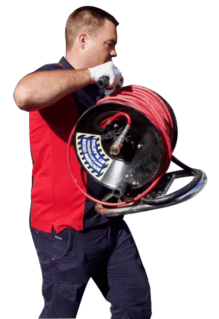 Plumber carrying a jet blast hose