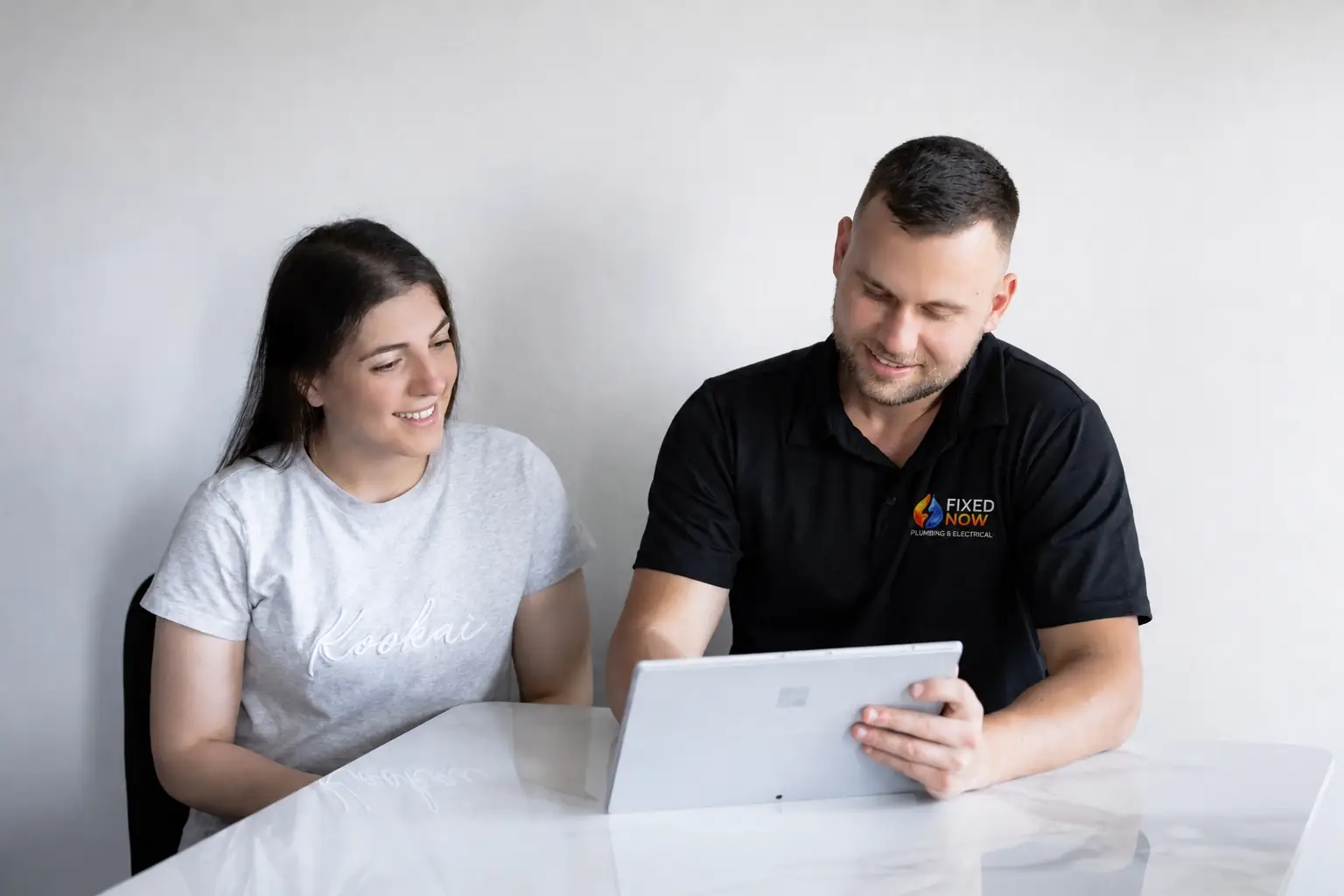 Fixed Now Drainage expert Sitting with a client explaining the best drainage solution